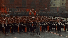 a large group of soldiers marching in a parade holding instruments