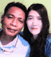 a man and a woman are posing for a picture and the woman is wearing glasses .