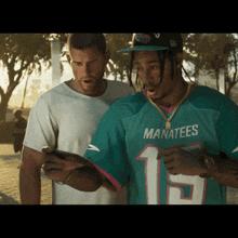 a man in a manatees jersey looks at a cell phone