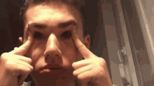 a close up of a person 's face with their hands on their eyes