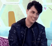 a young man is sitting on a couch and smiling .