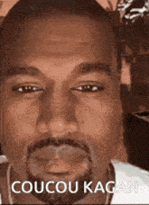 a close up of a man 's face with the words coucou kagan below him