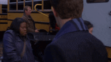 a group of people are standing in front of a yellow school bus that says public