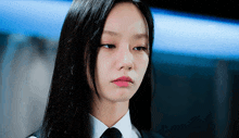 a woman with long black hair is wearing a white shirt and black tie