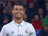 a soccer player wearing a white adidas shirt smiles