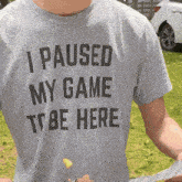 a man is wearing a t-shirt that says i paused my game to be here