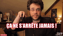 a man is holding a computer mouse in front of a screen that says ca ne s ' arrete jamais !