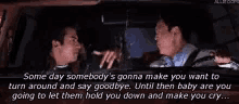 two men are sitting in a car and one of them is holding a baby .