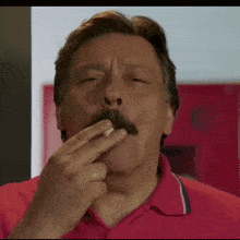 a man in a red shirt smoking a cigarette