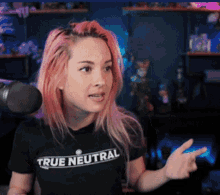 a woman with pink hair wearing a true neutral shirt