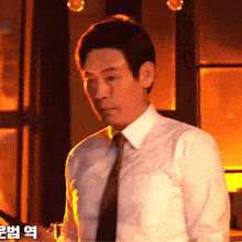 a man in a white shirt and tie is looking down