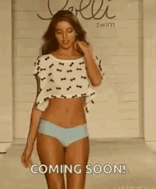 a woman in a bikini is dancing with her arms in the air and says `` coming soon ! ''