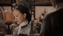 a woman in a traditional costume is sitting at a table with a man .