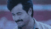 a man with a mustache is smiling with his eyes closed in a close up of his face .