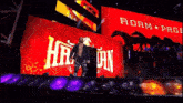 a wrestler is walking in front of a large screen that says adam page