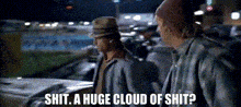 two men are standing next to each other in a parking lot and one of them is saying " shit a huge cloud of shit " .