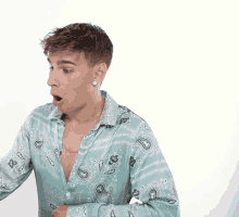 a man wearing a paisley shirt has his mouth wide open