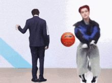 a man in a suit is throwing a basketball to another man in a blue jacket