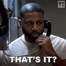 a man talking on a payphone with the words " that 's it " above him