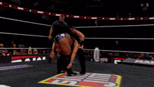 two wrestlers are wrestling in a ring with a sign that says raw on it