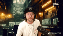 a man wearing headphones and a hat with a smiley face on it stands in front of a sign that says revolution