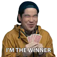 a man holding playing cards with the words i 'm the winner on the bottom