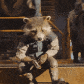 a raccoon is sitting on a box with a gun in its hands