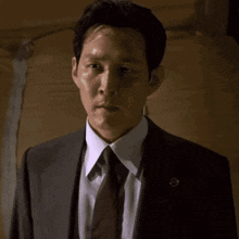 a man in a suit and tie with a cat 's face behind him