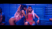 ariana grande and nicki minaj are kissing each other on the cheek in a video .