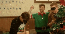 a group of men are standing around a christmas tree in a room .