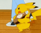 a pikachu is holding a bottle of choccy milk .