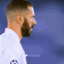 a man with a beard is wearing a white shirt with a star on the shoulder