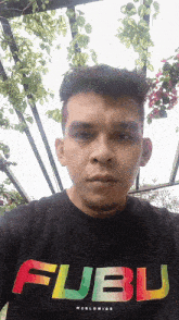 a man wearing a flubu worldwide shirt looks at the camera