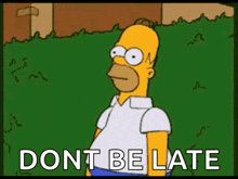 homer simpson is standing in the grass with the words `` dont be late '' written on the screen .