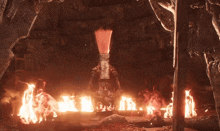a statue is surrounded by flames in a dark room