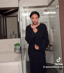 a woman in a black robe is standing in a bathroom next to a tub with a tiktok watermark