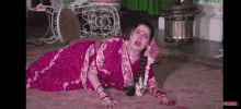 a woman in a pink dress is laying on the floor in a room .