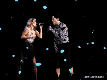 a woman singing into a microphone next to a man singing into a microphone with the words anahioverdose below them