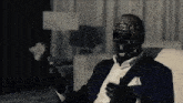 a man in a suit has a black mask on his head