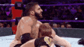 a man with a beard is wrestling another man in a ring