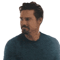 a man with a beard wearing a blue shirt looks to the side