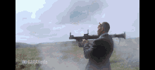 a man in a suit holding a rocket launcher in a field