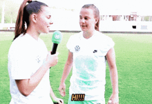two female soccer players are talking to each other on a field and one of them is wearing a shirt with volkswagen on it