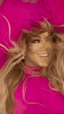 a close up of a woman wearing a pink hat and a pink dress .