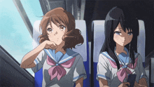 two anime girls are sitting next to each other on a plane