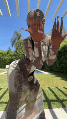 a woman covering her face with her hands while wearing a dress