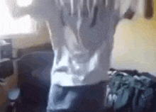 a person is standing in a room wearing a white shirt and jeans .