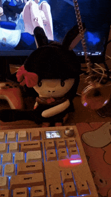 a stuffed animal is sitting on top of a keyboard with the enter key lit up