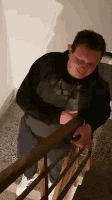 a man standing on a set of stairs looking at his cell phone