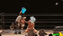 two men are wrestling in a ring and one has a cartoon character on his face
